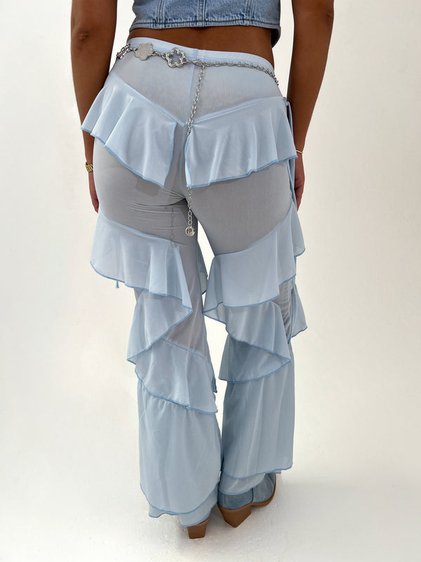 Light blue ruffled pants worn by a person on a white background