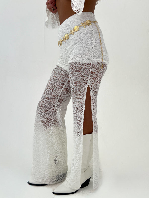 woman in a white outfit and gold belt on a white background