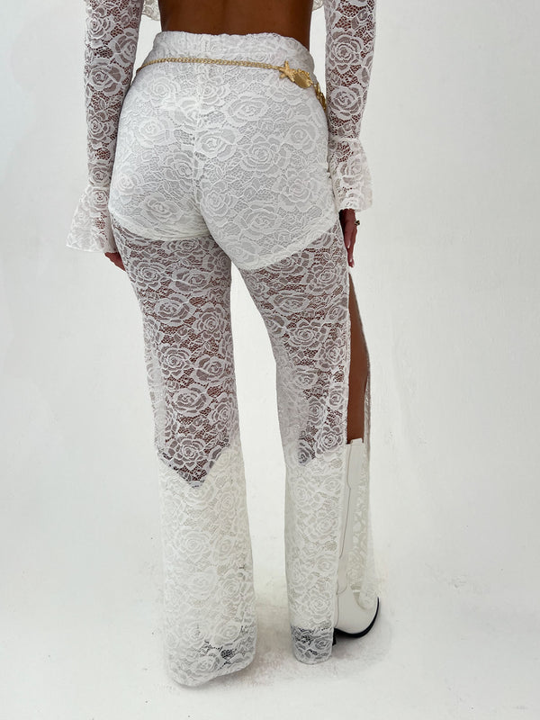 woman in a white outfit and gold belt on a white background