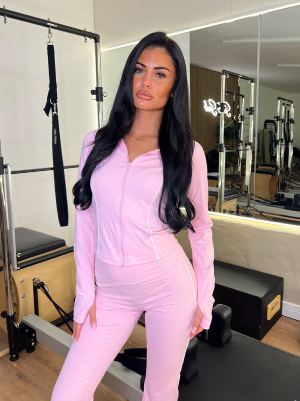Woman in a pink outfit standing in a gym setting