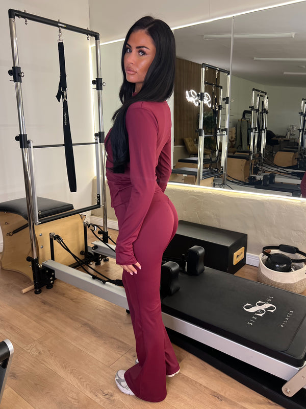 Burgundy Zip Jacket & Wide Leg Trouser Gym Set gym set, side view in modern Pilates studio
