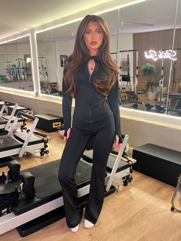 Black Zip Jacket Wide Leg Trouser Gym Set women's athleisure set, front view in Pilates studio