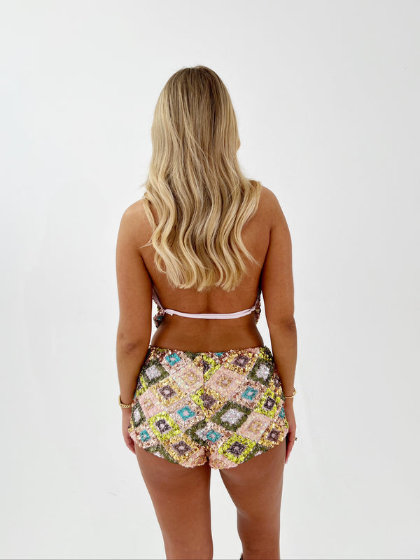 Woman wearing a sequin two-piece swimsuit on a white background