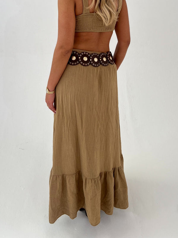 woman in a camel outfit with brown  belt on a white background