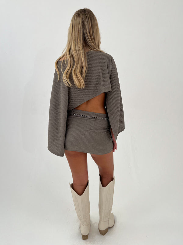 woman in a stone outfit with beige boots and silver belt