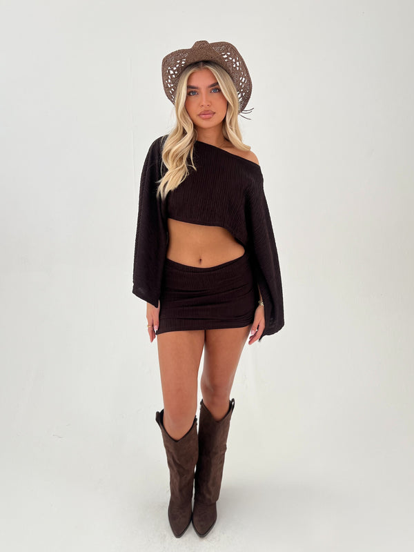 woman in a chocolate brown outfit with chocolate brown boots and hats