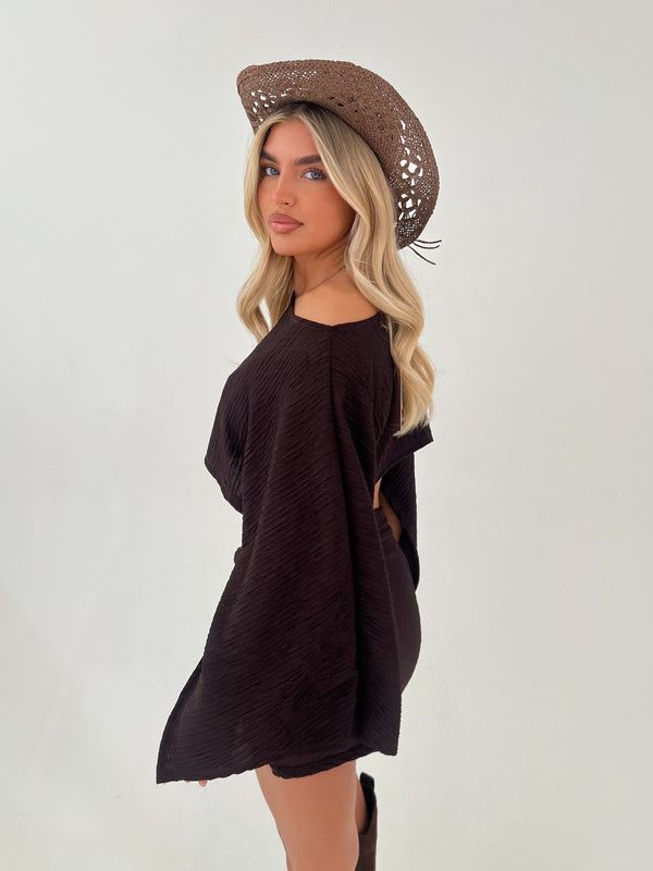 woman in a chocolate brown outfit with chocolate brown hat