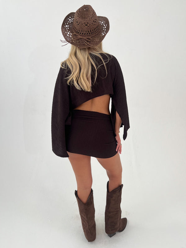 woman in a chocolate brown outfit with chocolate brown boots and hats