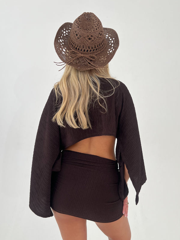 woman in a chocolate brown outfit with chocolate brown hat