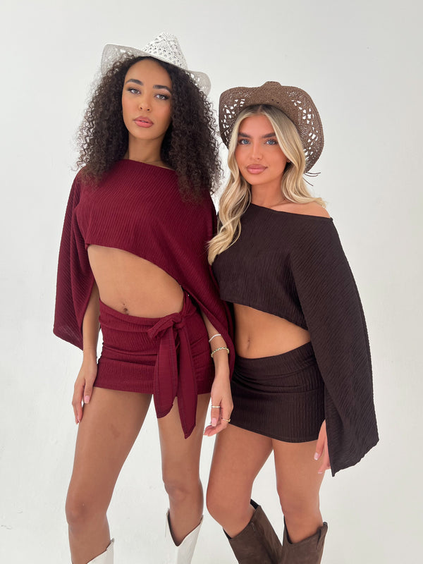 Lady in a burgundy outfit with white hat and boots Lady in a brown outfit with brown hat and boots on a white background