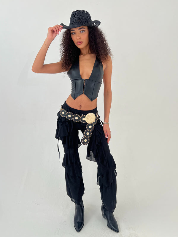 Woman wearing a black leather outfit with a hat on a white background