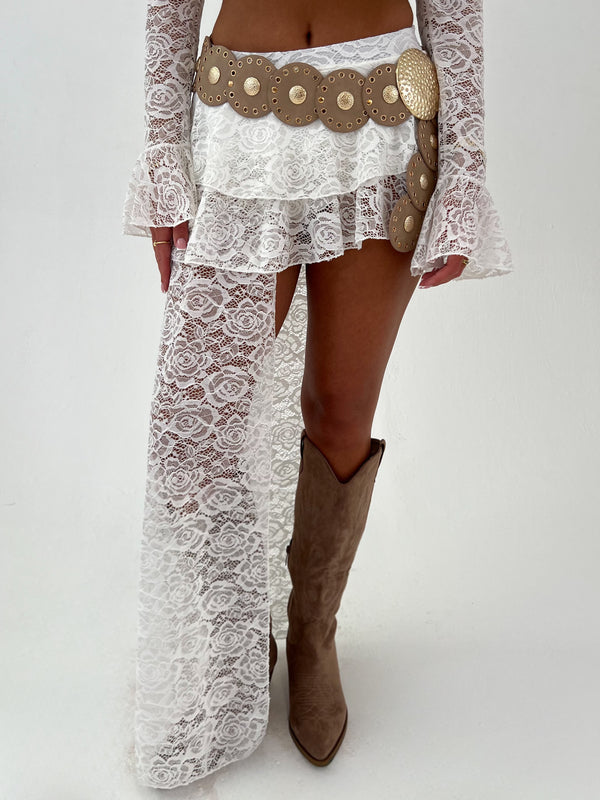 Woman wearing a white lace outfit with gold accents on a white background