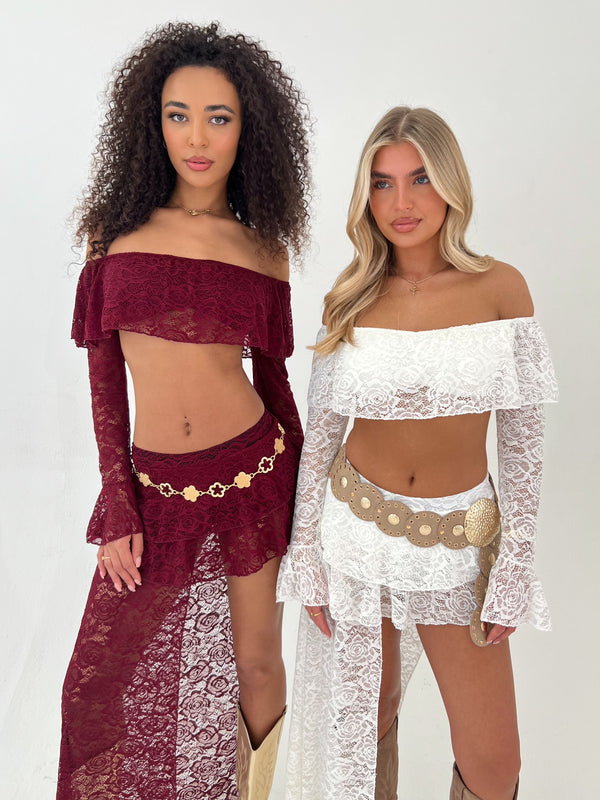 two Ladies wearing burgundy and white lace top and skirt with a gold belt on a white background