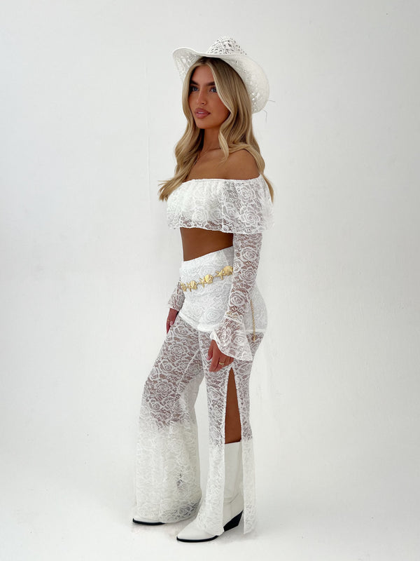 woman in a white outfit with white hat and gold belt on a white background