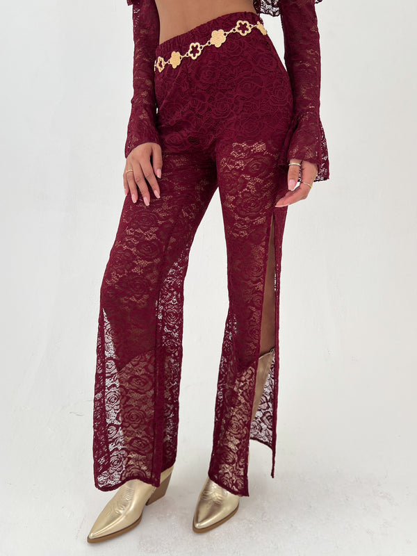 woman in a burgundy outfit with gold hat, belt and boots