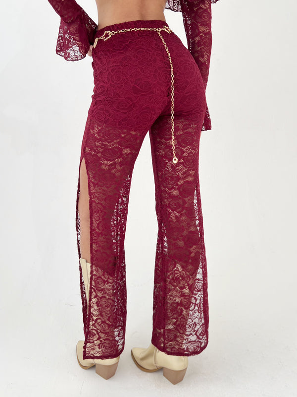 woman in a burgundy outfit with gold hat, belt and boots
