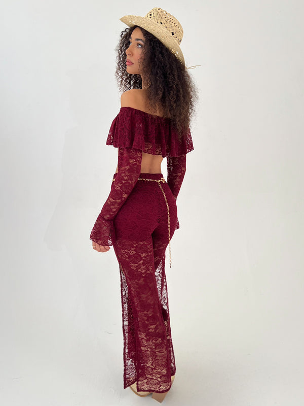 woman in a burgundy outfit with gold hat, belt and boots
