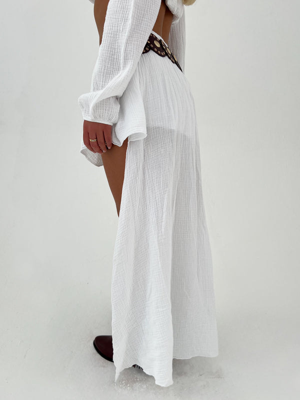 woman in white skirt with burgundy belt and boots