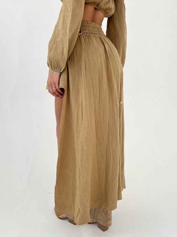 Person wearing a long camel skirt on a white background