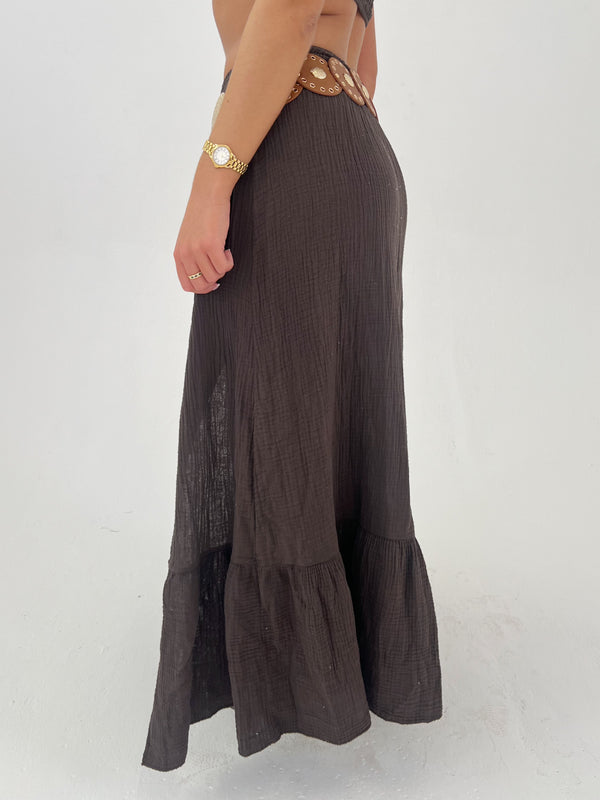 Brown maxi skirt worn by a person on a white background