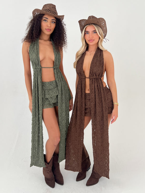 Two women wearing matching outfits with cowboy hats on a white background