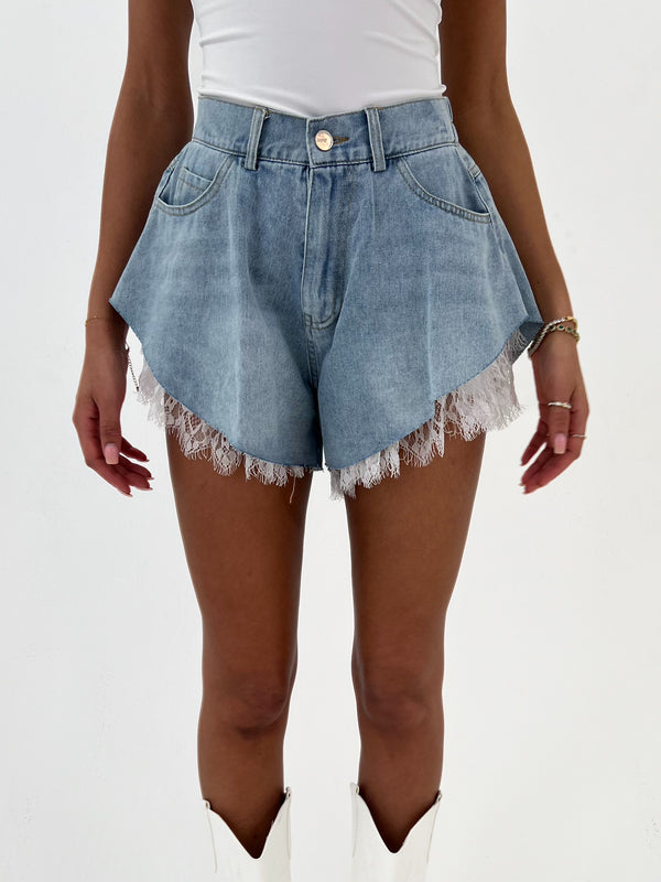 Denim shorts with frayed hem on a white background