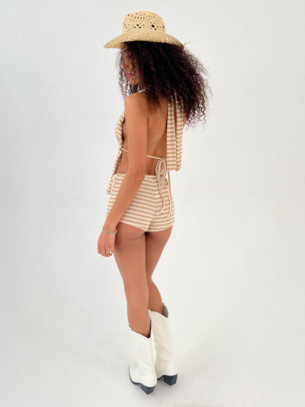 Woman wearing a striped outfit with a hat and boots on a white background