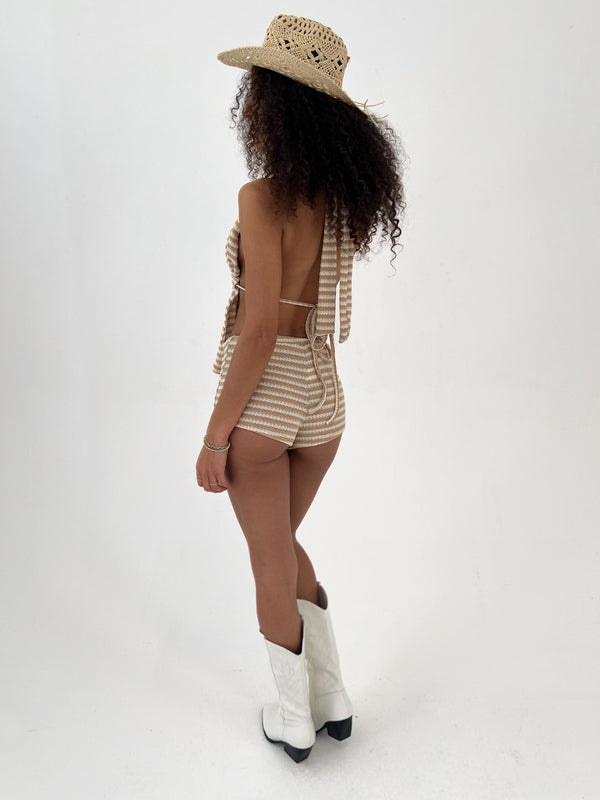 Person wearing a striped outfit, hat, and white boots on a white background