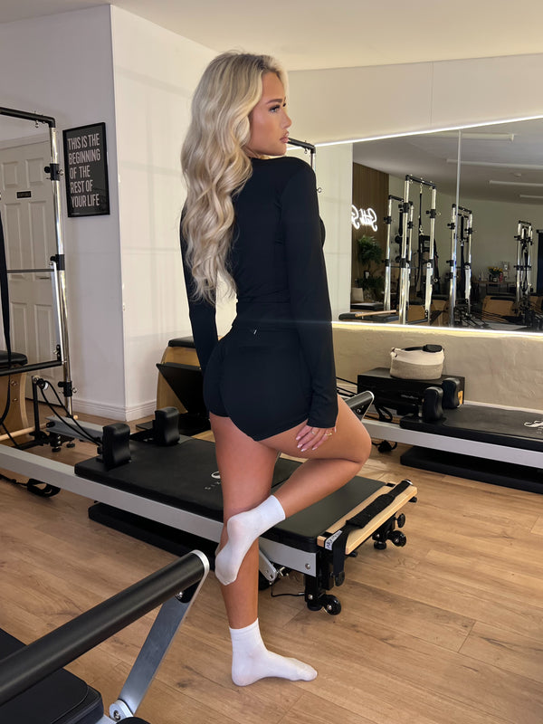Woman in a black outfit standing in a gym